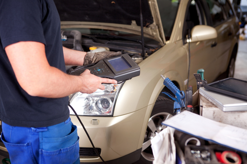 Detail of a mechanic with an electronic engine diagnostics tool